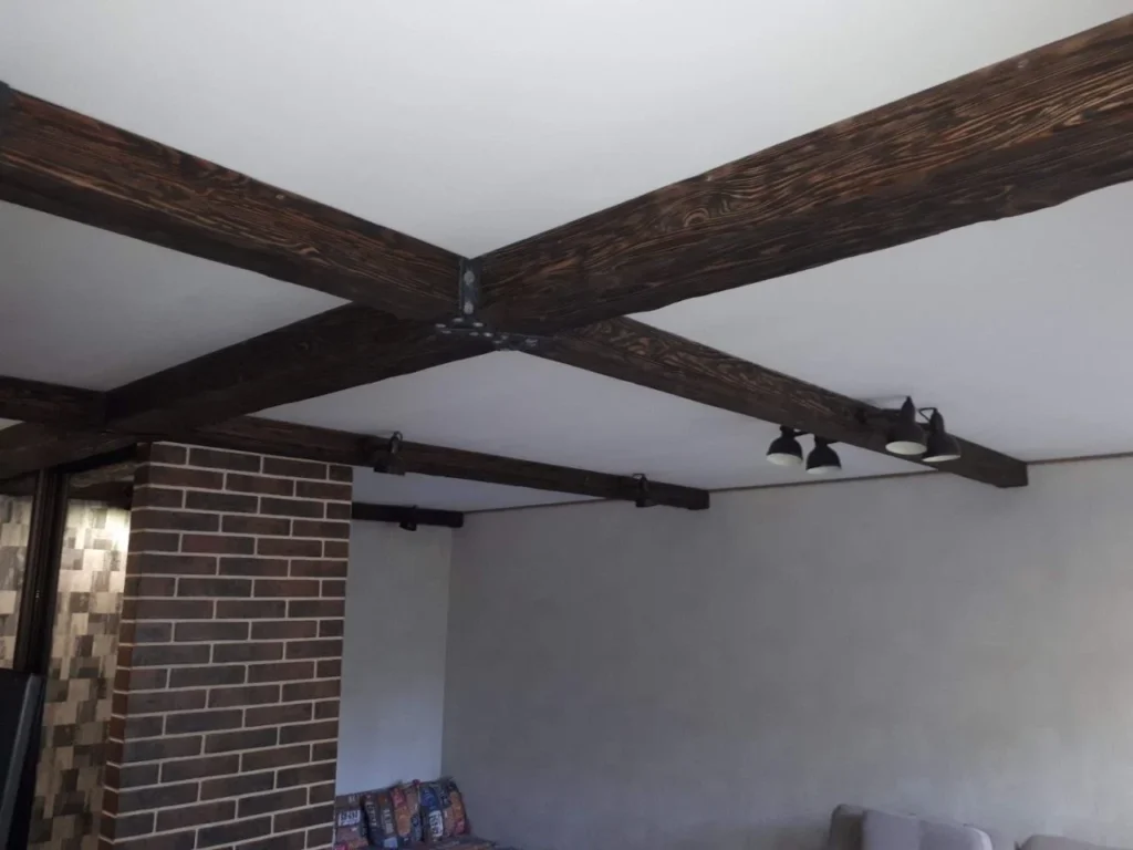 A single dark beam running across a plain white ceiling