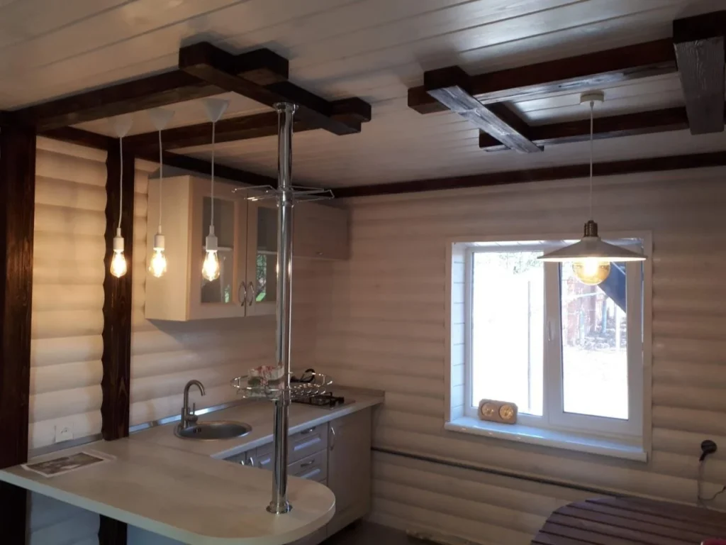 Room with dark exposed ceiling beams and a window at the gable end