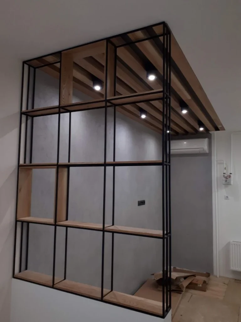 Black steel framed glazed partition dividing a room